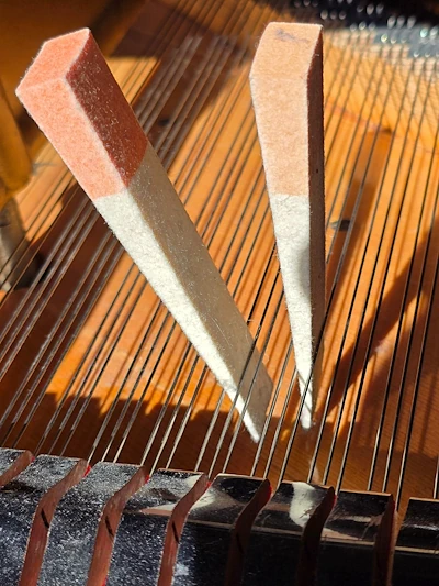 Sourdines en feutre placées entre les cordes d’un piano à queue pour étouffer certaines cordes pendant l’accordage.